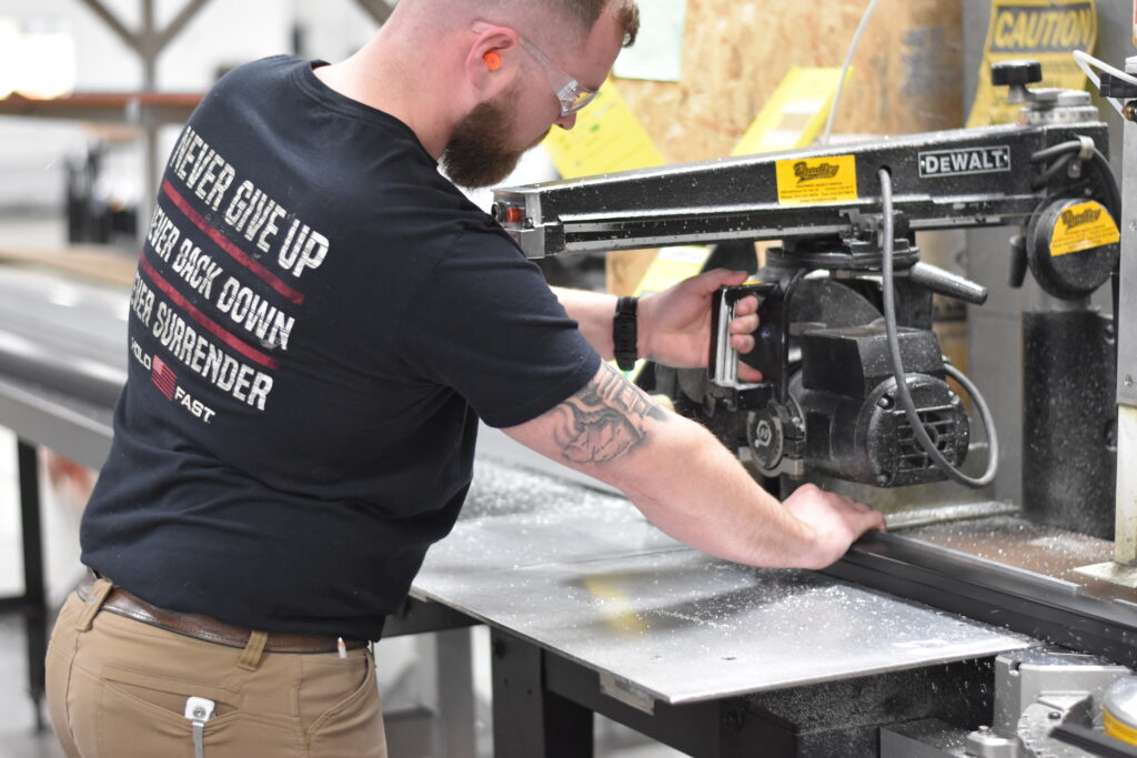Man using a saw to cut tubing