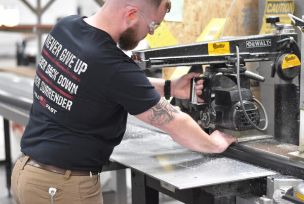 Man using a saw to cut tubing